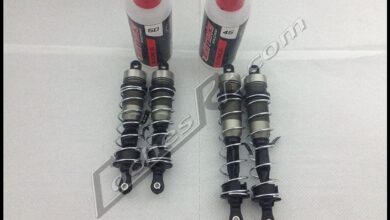 Dos amortiguadores de coche RC junto a sus botes de aceite
