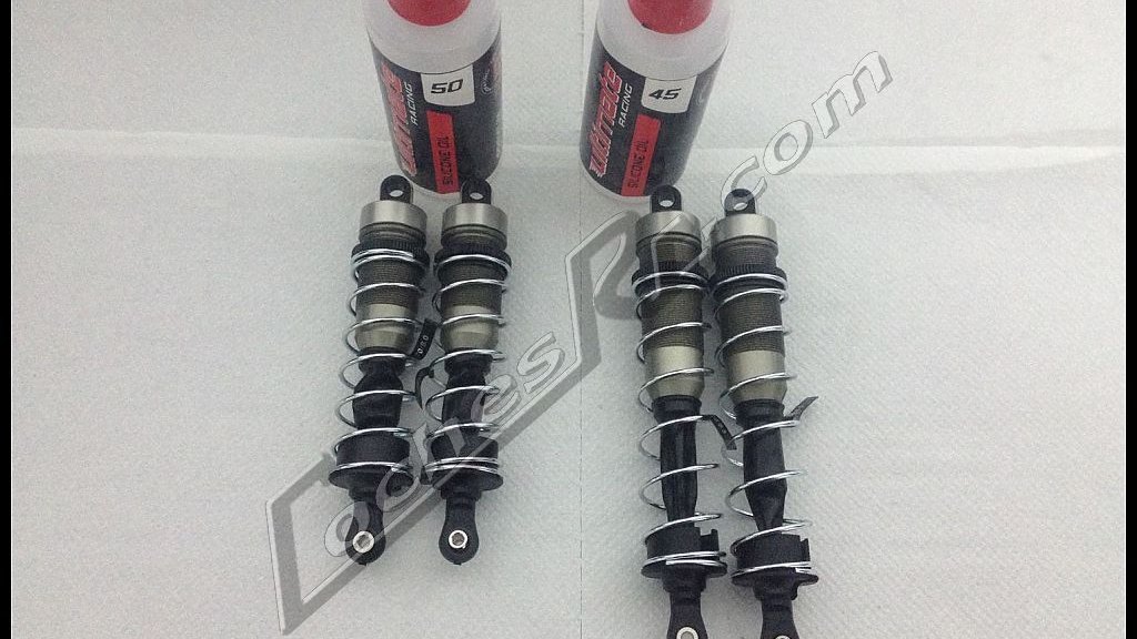 Dos amortiguadores de coche RC junto a sus botes de aceite