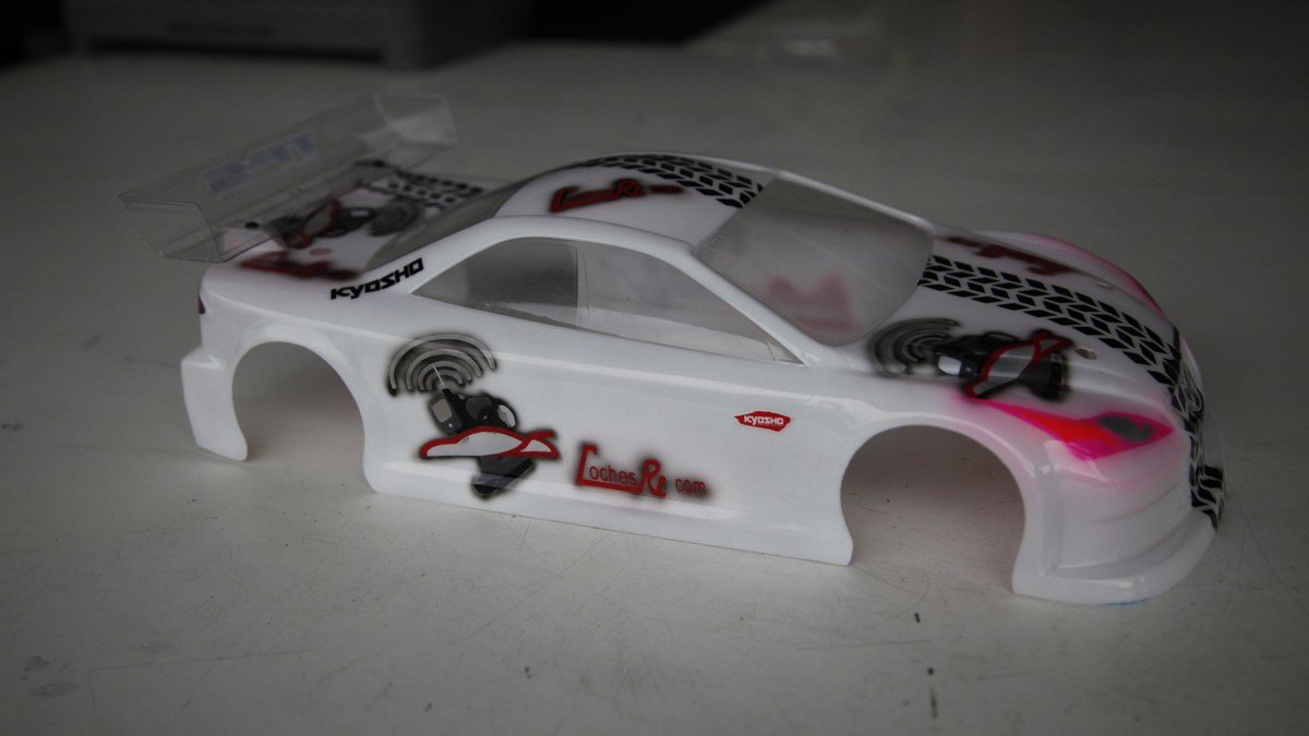 Carrocería de lexan de un coche RC pintada en blanco, rosa y negro, terminada y recortada