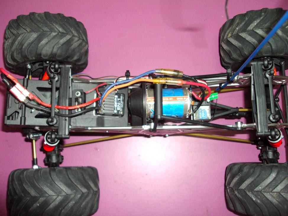 Chasis de un crawler visto por debajo, con el motor, el variador y el cableado entre las cuatro ruedas