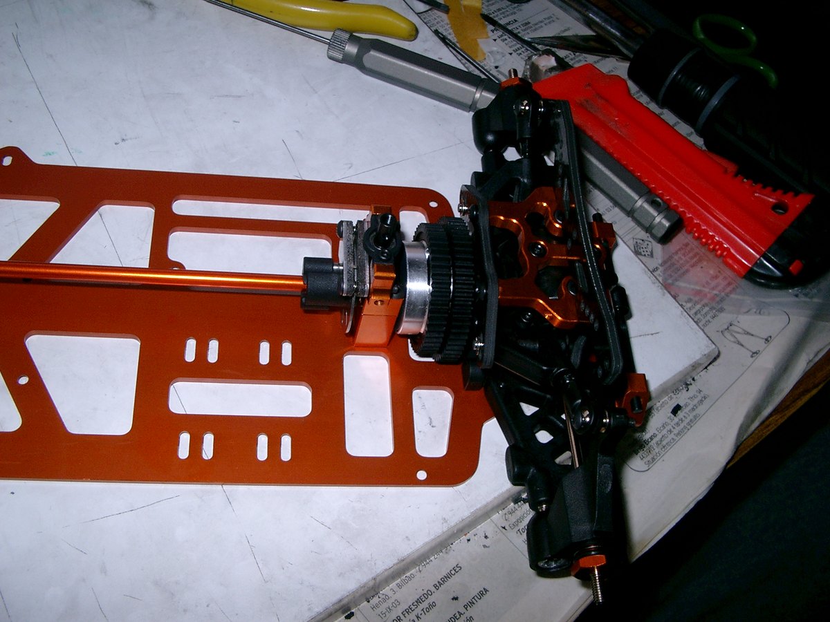 Chasis de aluminio de coche RC desnudo sobre la mesa de montaje