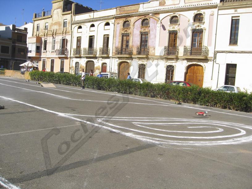 Circuito de coches de radiocontrol trazado con pintura sobre el asfalto de una calle
