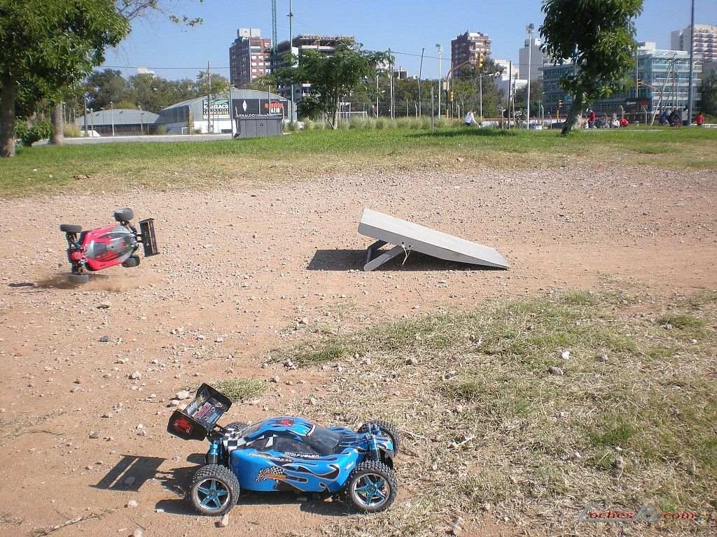 Buggy de radiocontrol rodando sobre tierra junto a una rampa