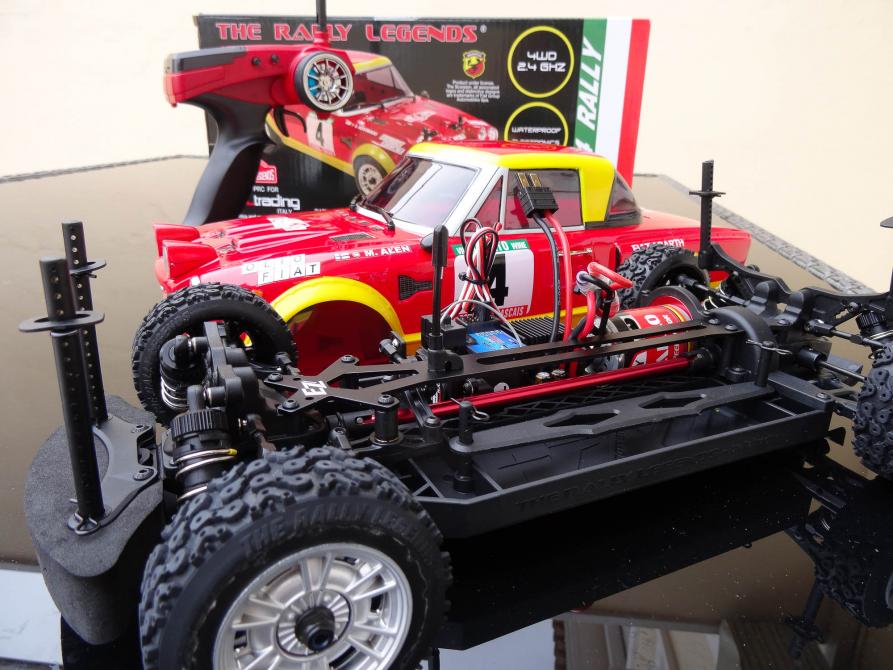 Coche de radiocontrol de rally recién desembalado, con su emisora y la caja del kit detrás