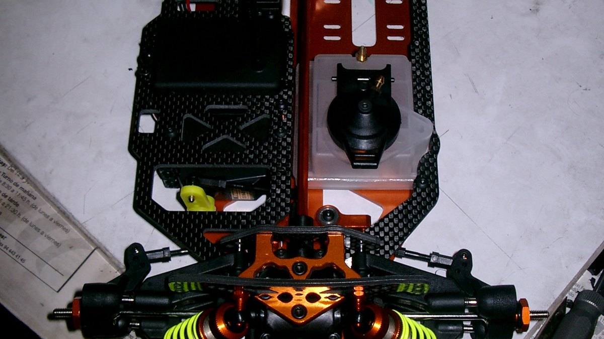 Chasis de coche RC en la mesa de trabajo rodeado de herramientas