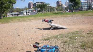 Buggy de radiocontrol todo terreno en el aire tras saltar una rampa de madera sobre un terreno de tierra