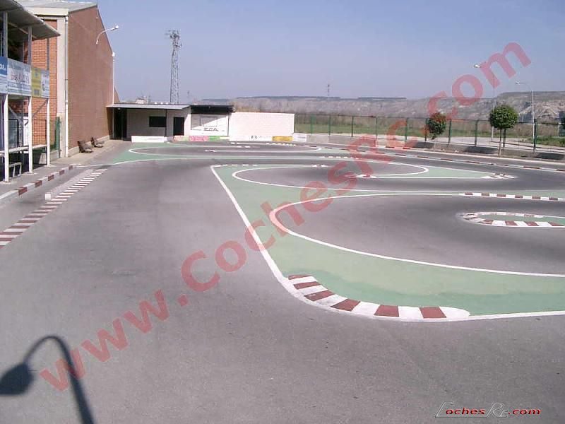 Coche RC touring de gasolina rodando en un circuito de asfalto