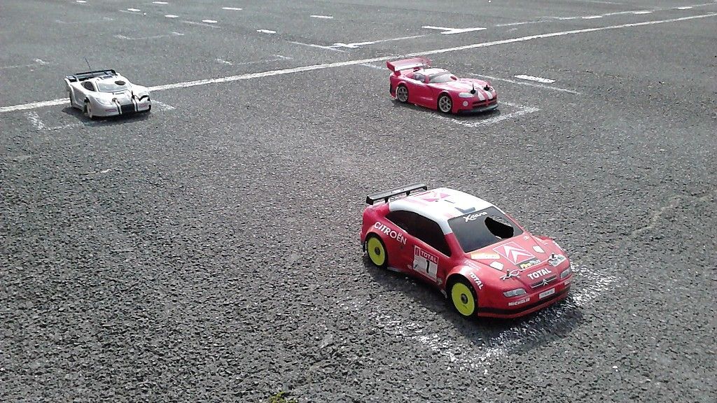 Varios coches de radiocontrol de pista rodando sobre asfalto