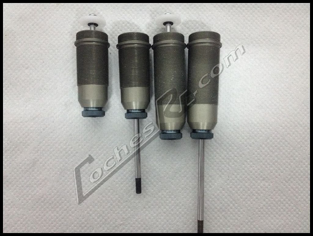 Los cuatro cuerpos de amortiguador de un coche RC alineados sobre la mesa