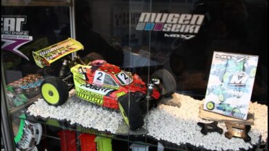 Vitrina de un fabricante de radiocontrol en la feria de Nuremberg con buggies expuestos sobre una maqueta de grava
