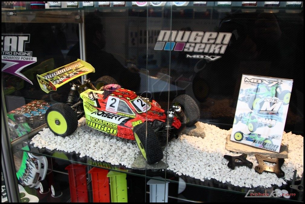 Vitrina de un fabricante de radiocontrol en la feria de Nuremberg con buggies expuestos sobre una maqueta de grava