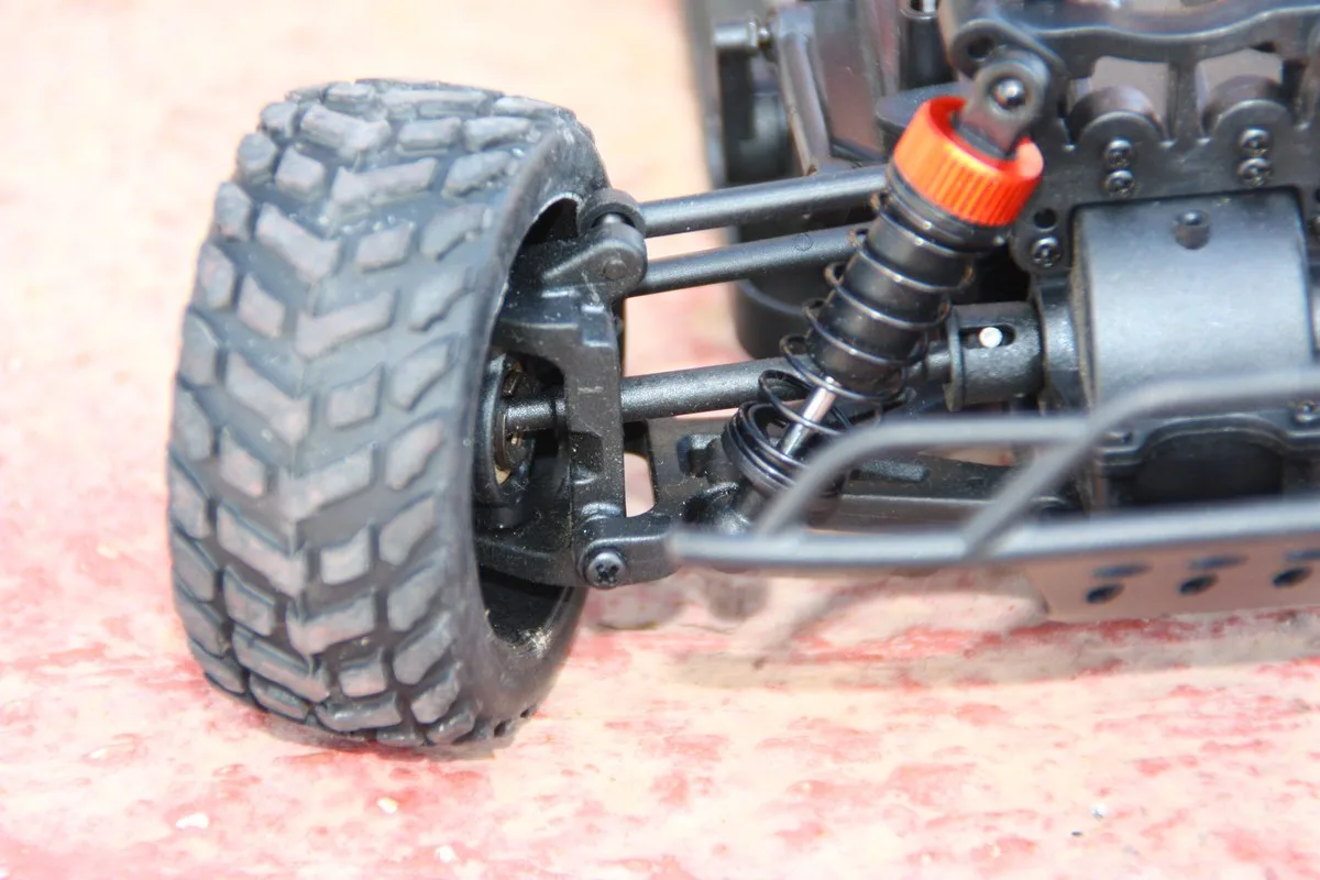 Primer plano de la mangueta de un coche RC con la bieleta de dirección enroscada