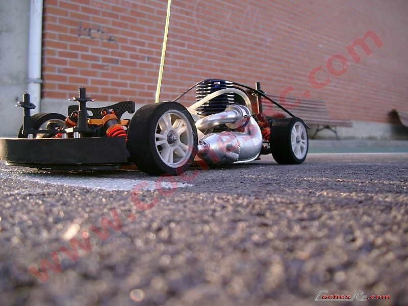 Motor nitro con su escape montado en un coche RC de pista