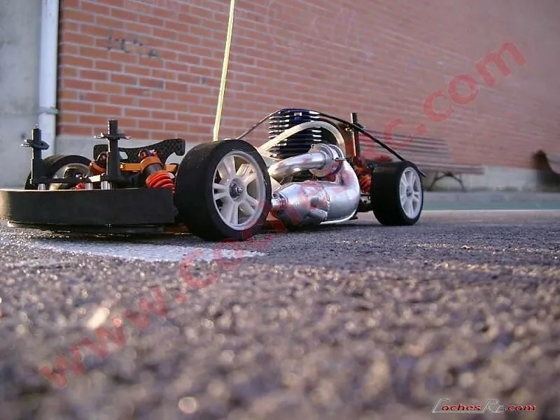 Motor nitro con su escape montado en un coche RC de pista