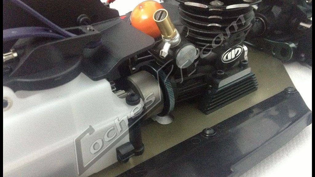 Motor nitro montado en el chasis de un coche RC con su deposito