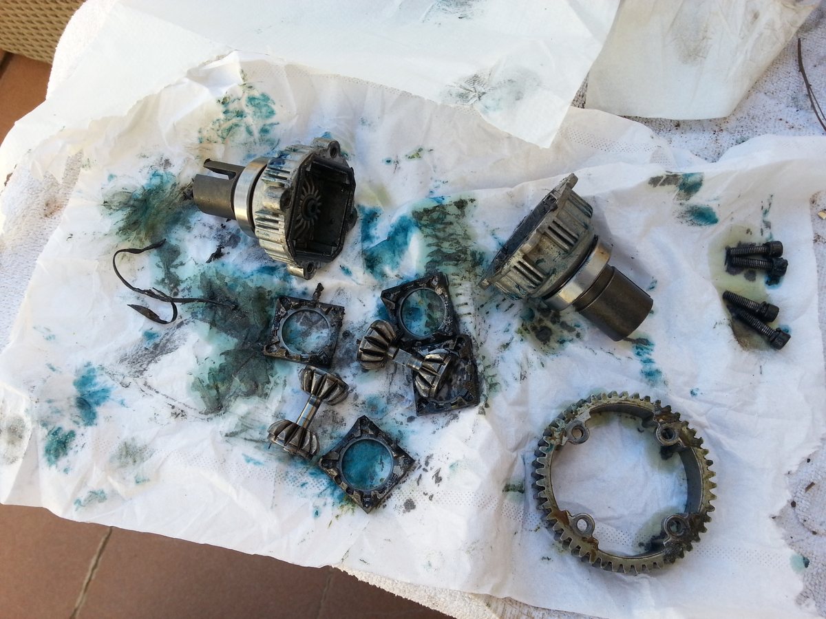 Piezas del diferencial de un coche RC sobre papel manchado de desengrasante