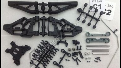 Trapecios y torretas de plastico de un kit de coche RC ordenados sobre la mesa
