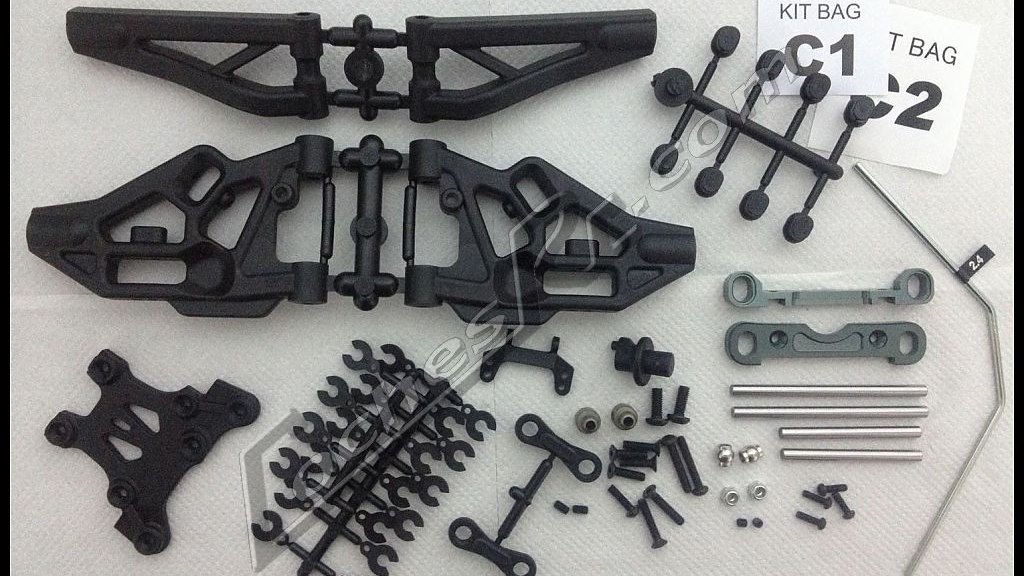 Trapecios y torretas de plastico de un kit de coche RC ordenados sobre la mesa