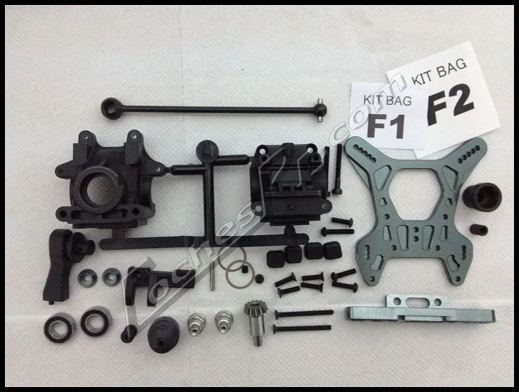 Piezas sueltas de un kit de coche RC ordenadas sobre una toalla en la mesa de trabajo