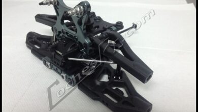 Piezas de plástico y tornillería de un coche RC preparadas sobre la mesa de trabajo