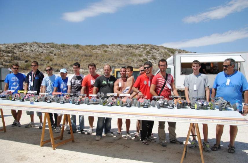Fila de pilotos detrás de la mesa con sus coches de radiocontrol preparados antes de una carrera