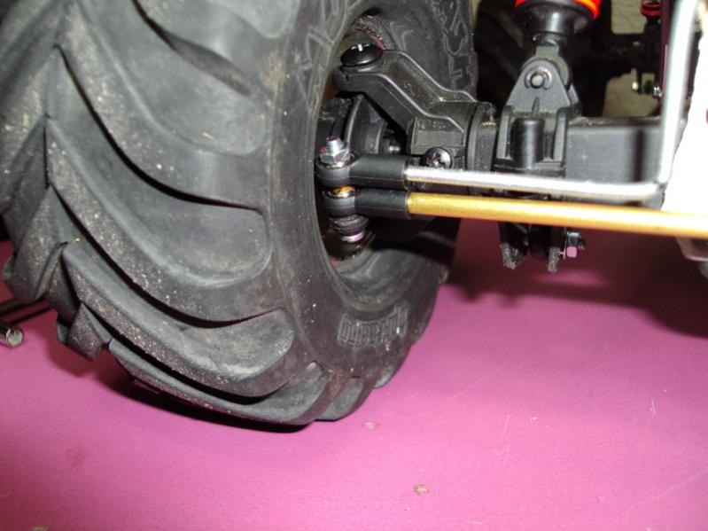 Primer plano de una rueda de monster truck con neumático de tacos duros, maza y rótula de dirección, antes de sustituirla por una rueda de crawler