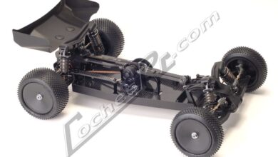 Buggy de competicion Schumacher Cougar KF de dos ruedas motrices, en negro y sin carroceria, visto de tres cuartos sobre fondo blanco