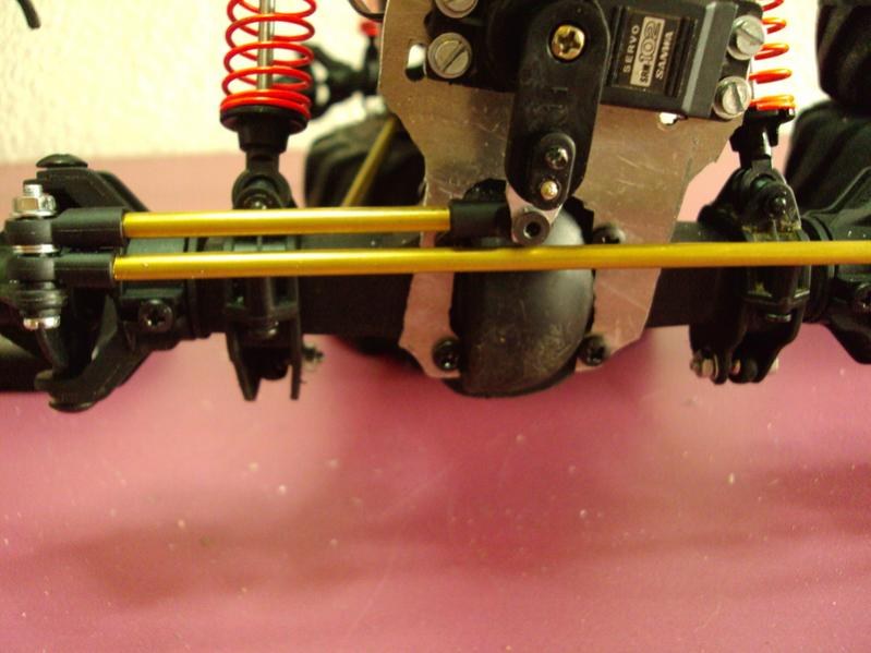 Servo de dirección Sanwa montado sobre una placa de aluminio en el eje delantero de un crawler, con las dos varillas de dirección paralelas