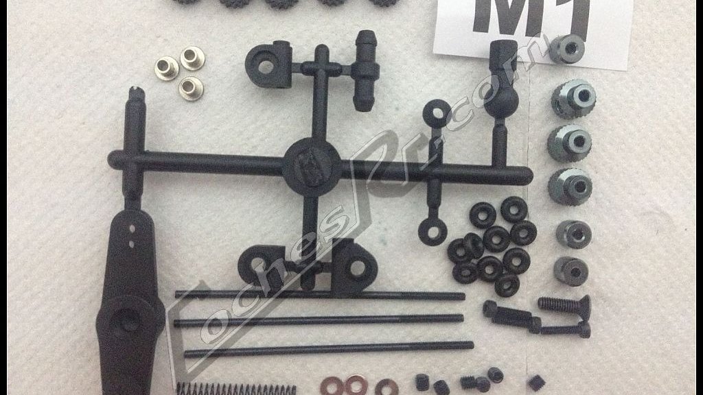 Servo, varillaje y pinones de un kit de coche RC ordenados sobre la mesa