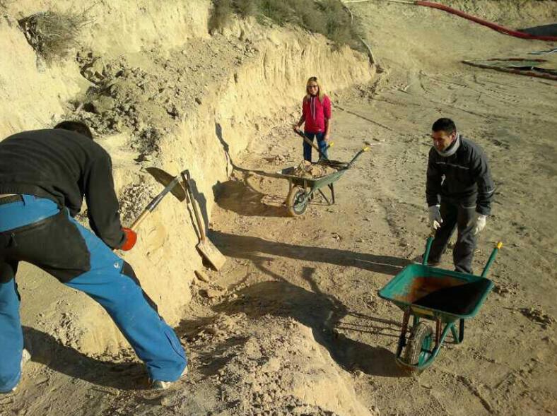 Socios del club excavando con palas y carretillas para dar forma al circuito de tierra