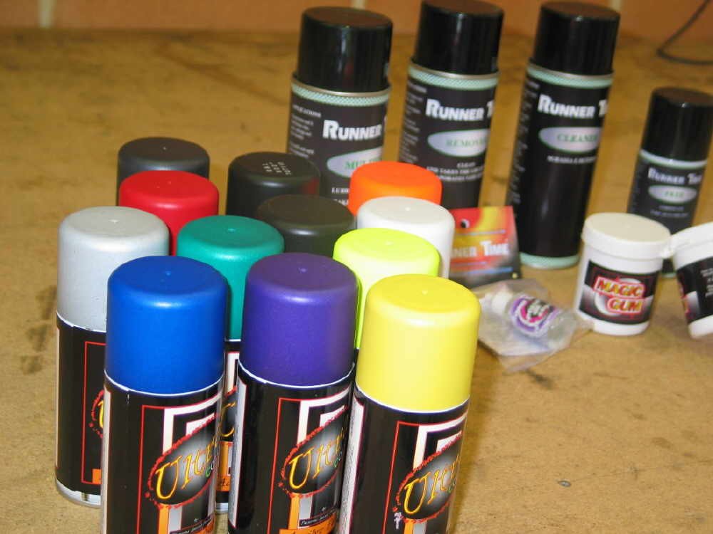 Botes de spray de pintura para lexan y desengrasante, alineados sobre la mesa