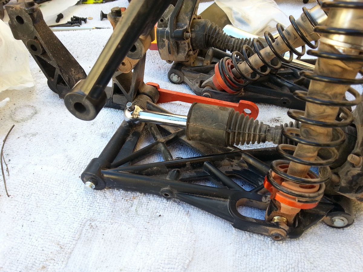 Amortiguadores y trapecios de un coche RC con barro seco pegado