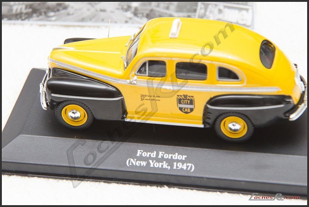 Miniatura del taxi Ford Fordor de Nueva York con la fotografía de la ciudad al fondo