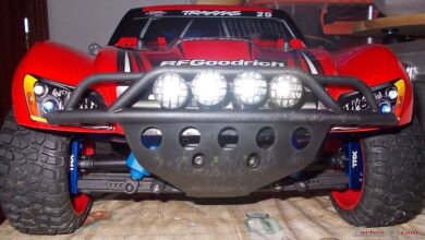 Frontal de un Traxxas Slash de short course rojo con parachoques tubular, faros y neumaticos todo terreno