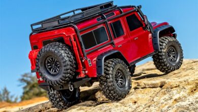 Traxxas TRX-4 con carroceria Land Rover Defender roja trepando por rocas